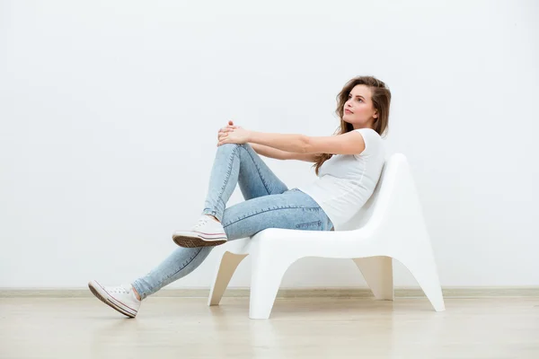 白い椅子に座っている単一の女性 — ストック写真