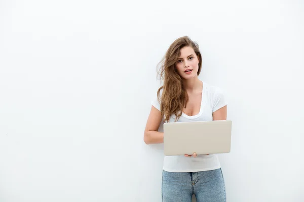 Mujer joven sosteniendo un ordenador portátil en blanco — Foto de Stock