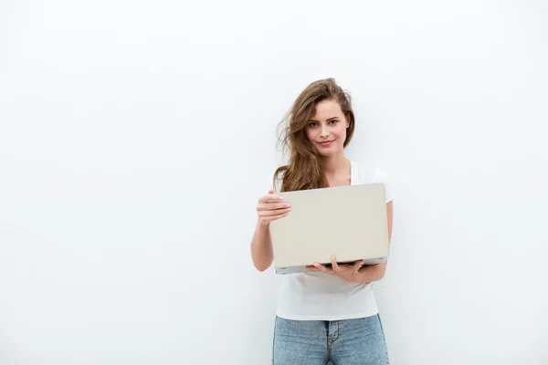 Mujer joven sosteniendo un ordenador portátil en blanco — Foto de Stock