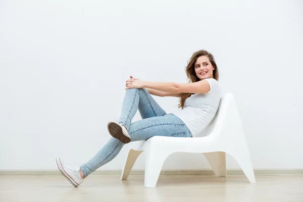 Single woman sitting on white chair — Stock Photo, Image