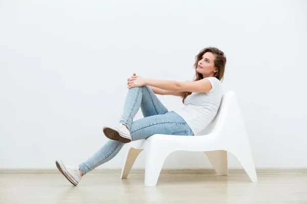 Žena sedící na bílé křeslo — Stock fotografie