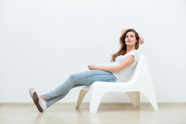 Alleenstaande vrouw zittend op witte stoel — Stockfoto