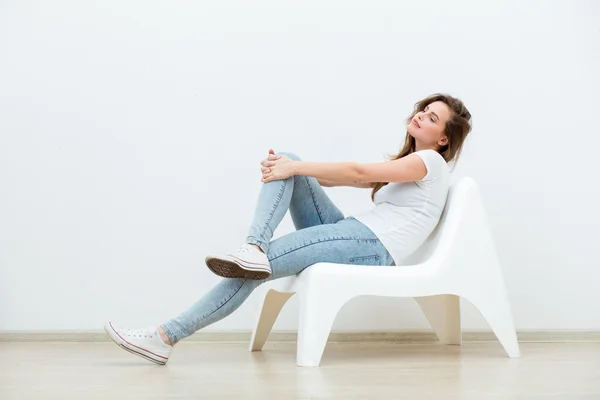 Single woman sitting on white chair — Stock Photo, Image