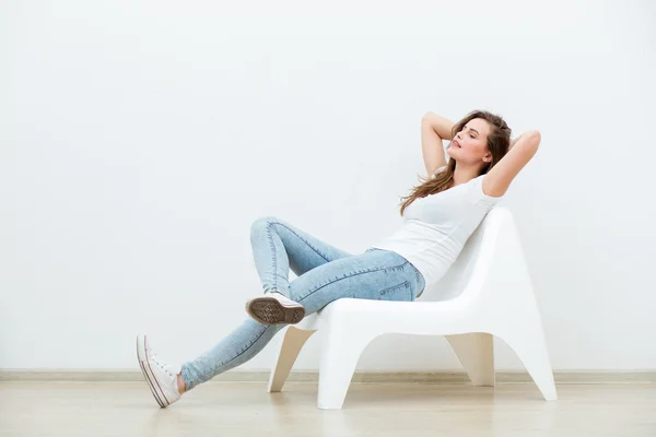 Žena sedící na bílé křeslo — Stock fotografie