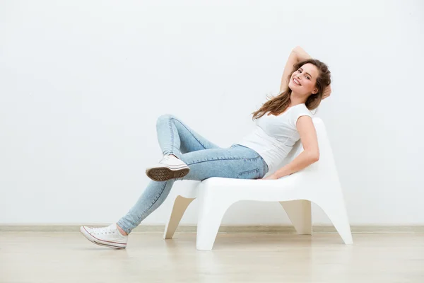 Mujer soltera sentada en silla blanca — Foto de Stock