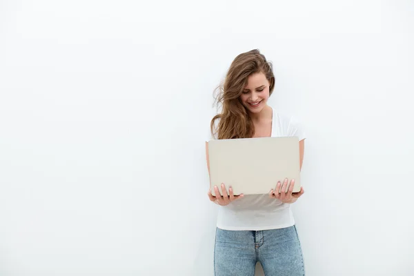 Giovane donna che tiene un computer portatile su bianco — Foto Stock
