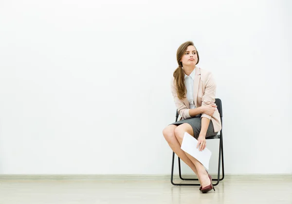 Vrouw in office outfit te wachten op een stoel — Stockfoto