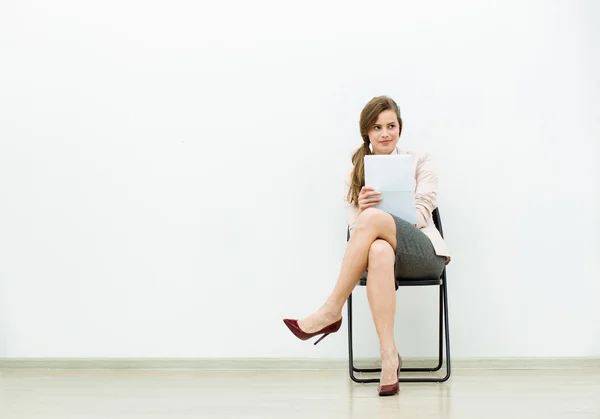 Vrouw in office outfit te wachten op een stoel — Stockfoto