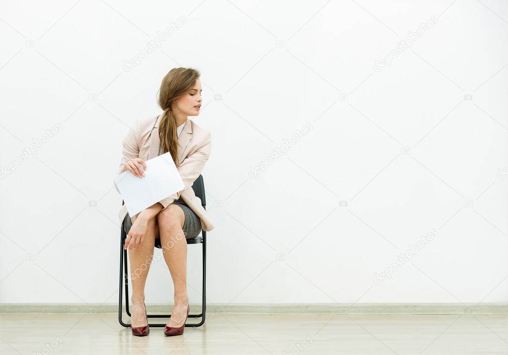 woman in office outfit waiting on a chair