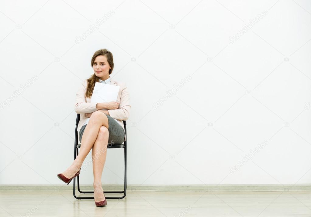 woman in office outfit waiting on a chair