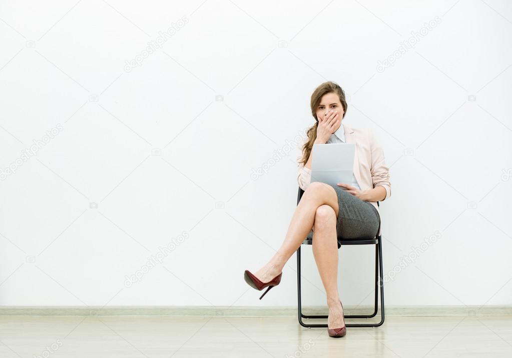 woman in office outfit waiting on a chair