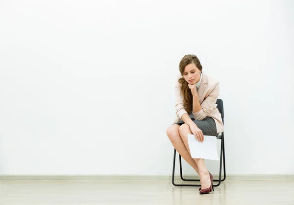 Mulher no escritório roupa esperando em uma cadeira — Fotografia de Stock