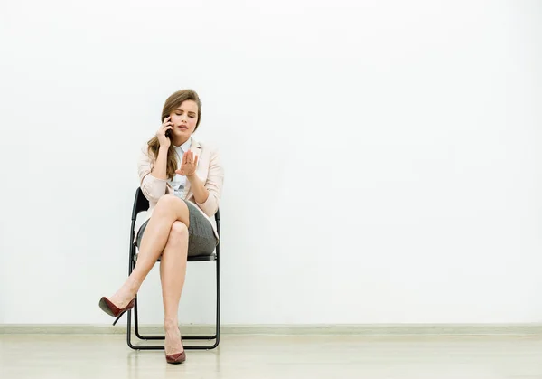 Kvinde i kontor outfit venter på en stol - Stock-foto
