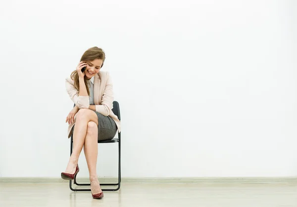 Vrouw in office outfit te wachten op een stoel — Stockfoto
