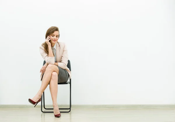 Mujer en traje de oficina esperando en una silla —  Fotos de Stock