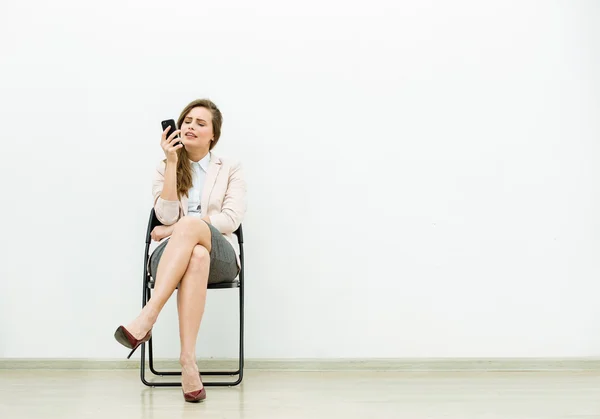 Kvinna i office outfit väntar på en stol — Stockfoto