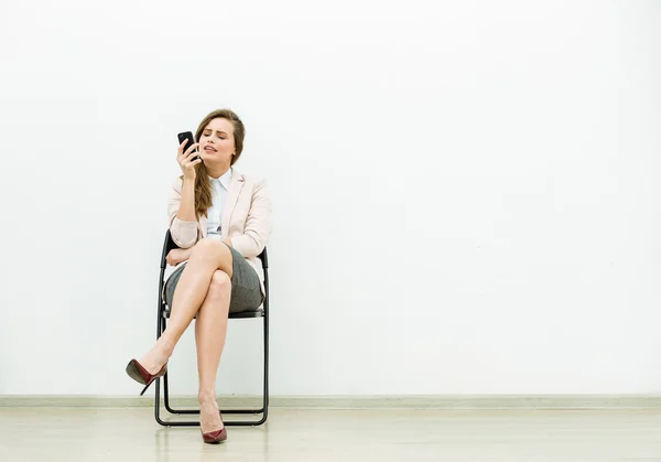 Mujer en traje de oficina esperando en una silla —  Fotos de Stock