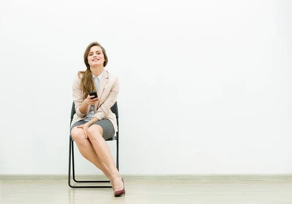 Mujer en traje de oficina esperando en una silla —  Fotos de Stock