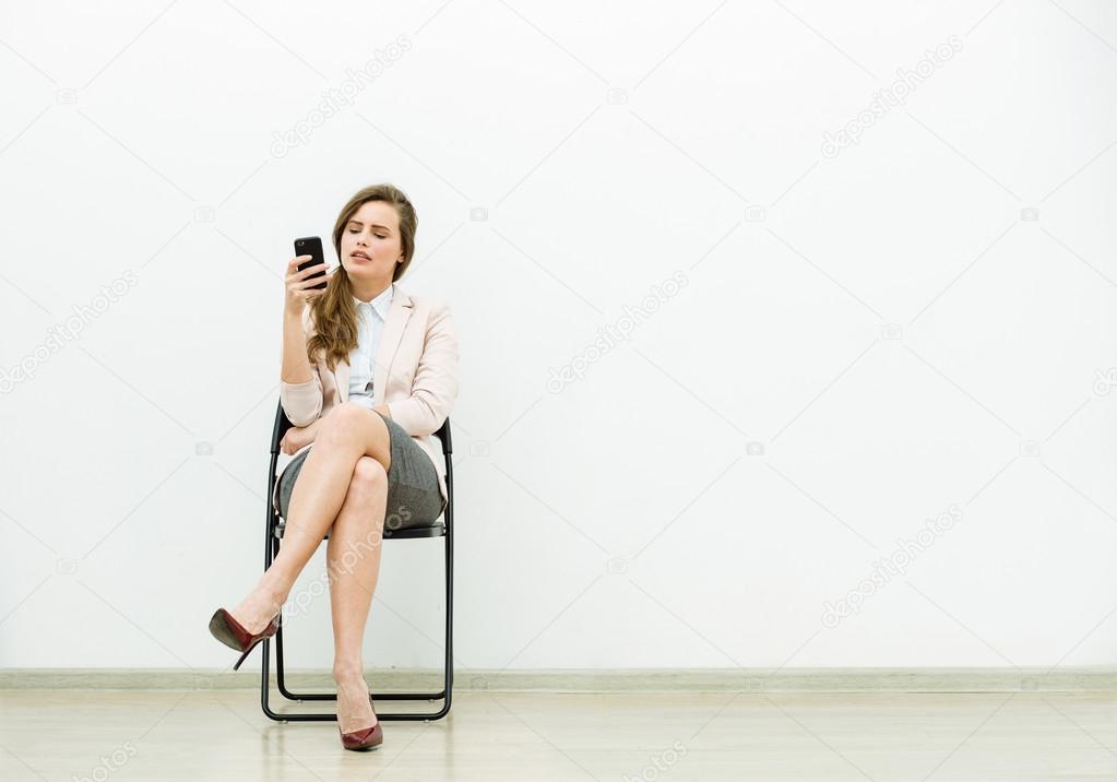 woman in office outfit waiting on a chair