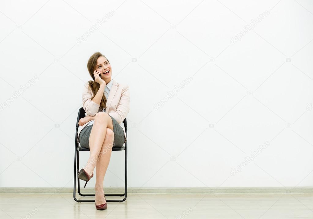 woman in office outfit waiting on a chair