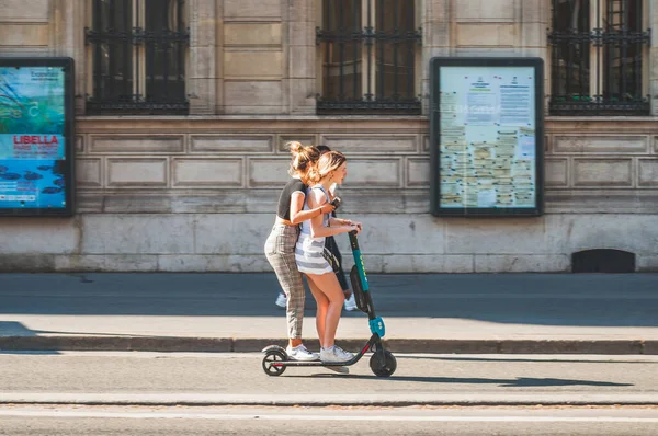 Paris, Fransa - 20 Nisan 2019 - Yolun ortasında elektrikli scooter süren genç kızlar