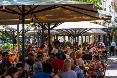 Ljubjana, Slovenya - 17 Ağustos 2019 - Başkentteki sıcak bir günde kalabalık restoranlarda öğle yemeği yiyen insanlar