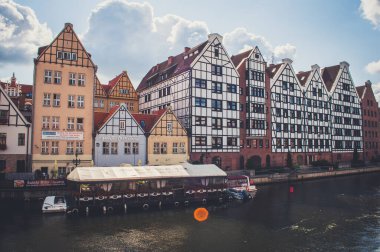 Gdansk, Polonya - 16 Ağustos 2018 - Arkadaki sabah güneşinin ışınlarında antik binalar ve restoranlar