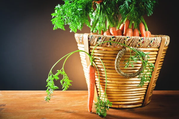 Bunch carrots in wooden basket — Stock Photo, Image