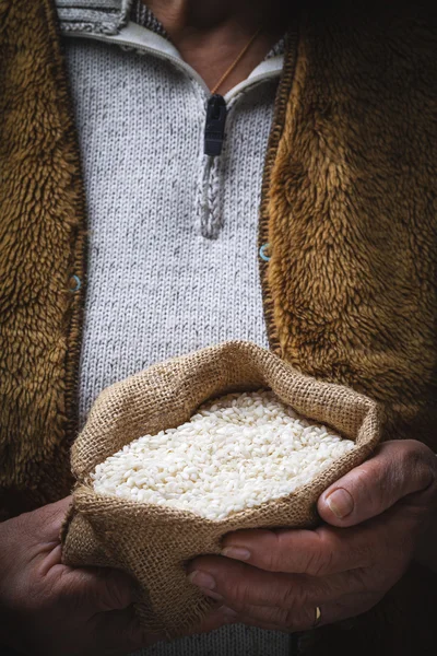 Arroz blanco en mano vieja —  Fotos de Stock