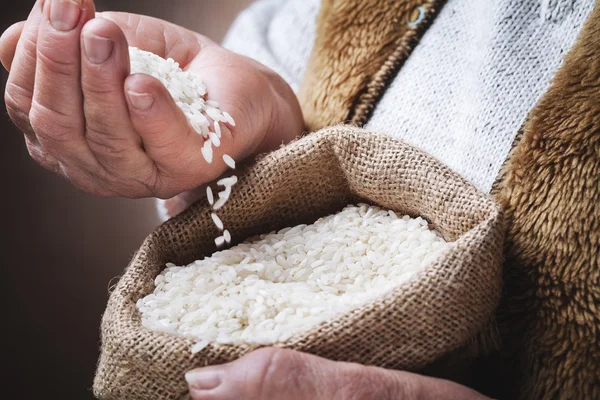 Arroz blanco en mano vieja —  Fotos de Stock