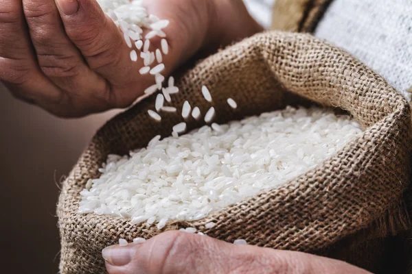 Arroz blanco en mano vieja —  Fotos de Stock