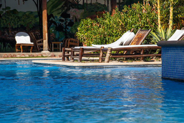 relaxing concept, pool with chairs to relax on holidays