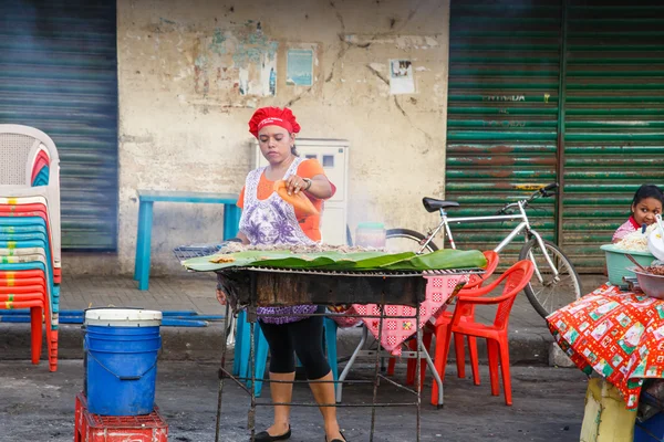 Lebensmittelverkäufer auf der Straße. Mädchen verkauft typisches Essen auf der Straße — Stockfoto