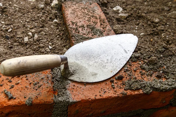 Construction lute trowels in a brick wall — Stock Photo, Image