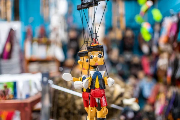 Two puppets of Pinocchio hanging from a toy stand. Jaco beach in Costa Rica