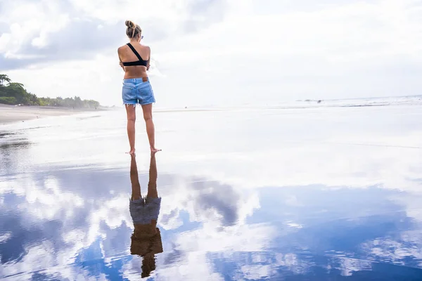Kvinna Står Strand Med Sin Siluett Och Himlen Reflekteras Vattnet — Stockfoto