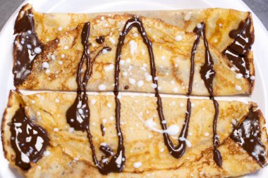 Üzerinde çikolata olan bir krepin havadan yakından görüntüsü.