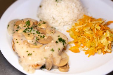 Mantar sosu ve sebzelerle süslenmiş karışık pirinç tabağını kapat.