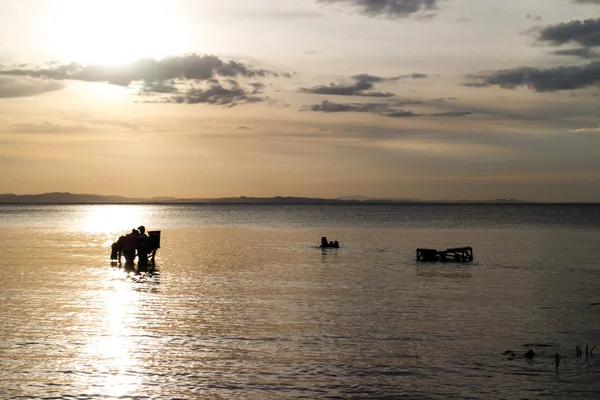 Croix-lumière des gens dans un lac — Photo