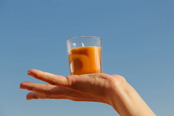 Orangefarbene Kerze auf einer Hand — Stockfoto