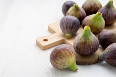 Tahta masadaki incirlerin üst görüntüsü, seçici odak, beyaz ahşap masa, yatay, kopyalama alanı olan