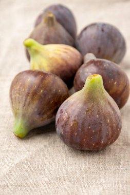 Gri masa örtüsündeki incirlerin üst görünümü, seçici odaklı, dikey