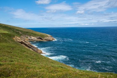 Uçurumlu deniz manzarası, güneşli bir yaz günü, Cantabria, İspanya 'nın kayalık sahillerinde, yatay.