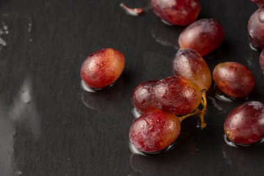 Islak tahtada ıslak kırmızı üzümlerin havadan görünüşü, seçici odak, arka ışık, yatay, fotokopi alanı