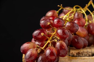 Kırmızı sügranineteen üzümlere yakın plan, seçici odak, siyah arkaplan, yatay, kopyalama alanı olan