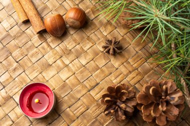 Kırmızı mum, çam kozalakları, fındık, tarçın ve yeşil dallarla örülmüş yüzey görüntüsü, seçici odak, yatay olarak, kopyalama alanı ile