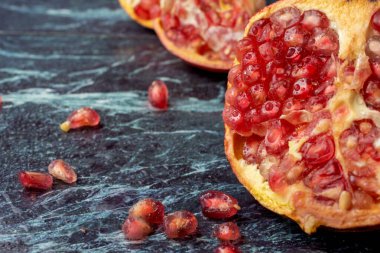 Makro yakın plan açık kırmızı nar, mavi mermer üzerinde tohumlar, seçici odaklı, yatay