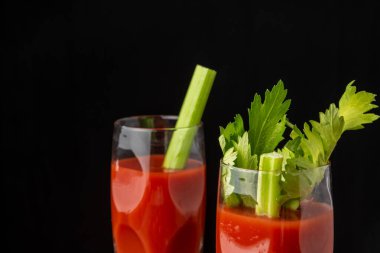 Bloody Mary kokteyli ile iki kristal bardağın üst görüntüsü, seçici odak, siyah arkaplan, yatay, kopyalama alanı ile