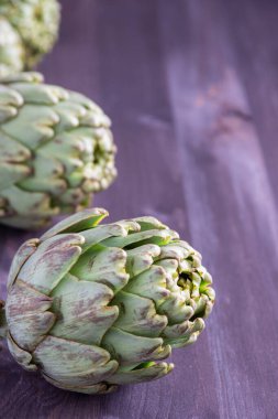 Yeşil enginarların üst görünümü, seçici odaklı, tahta masa üzerinde, dikey, kopyalama alanı ile