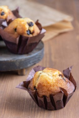 Çikolatalı keke yakın plan, seçici odak, tahta masa üzerinde kağıt torba, dikey